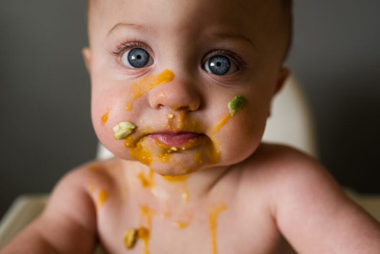 Baby,Eating,Solids,With,Food,All,Over,His,Face